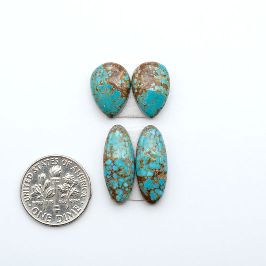 Number 8 Turquoise cabochons, blue and green color with brown matrix, polished stones on a white background, with a US dime for scale