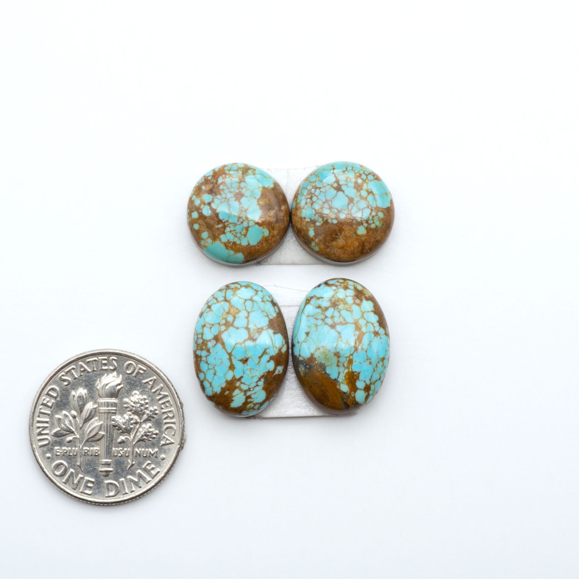 Number 8 Turquoise cabochons, blue and green color with brown matrix, polished stones on a white background, with a US dime for scale
