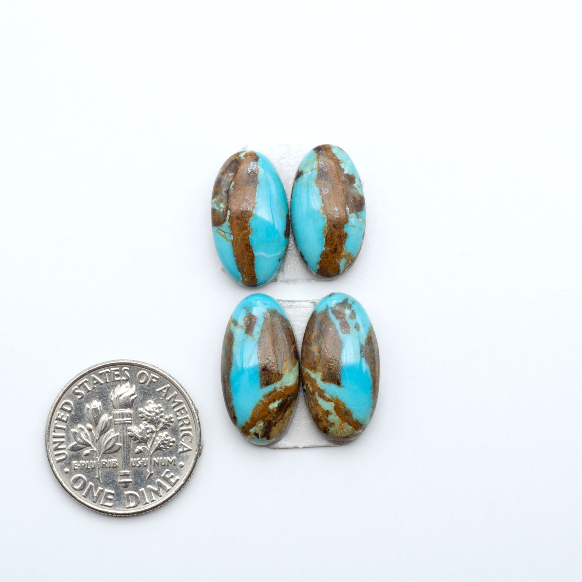 Number 8 Turquoise cabochons, blue and green color with brown matrix, polished stones on a white background, with a US dime for scale