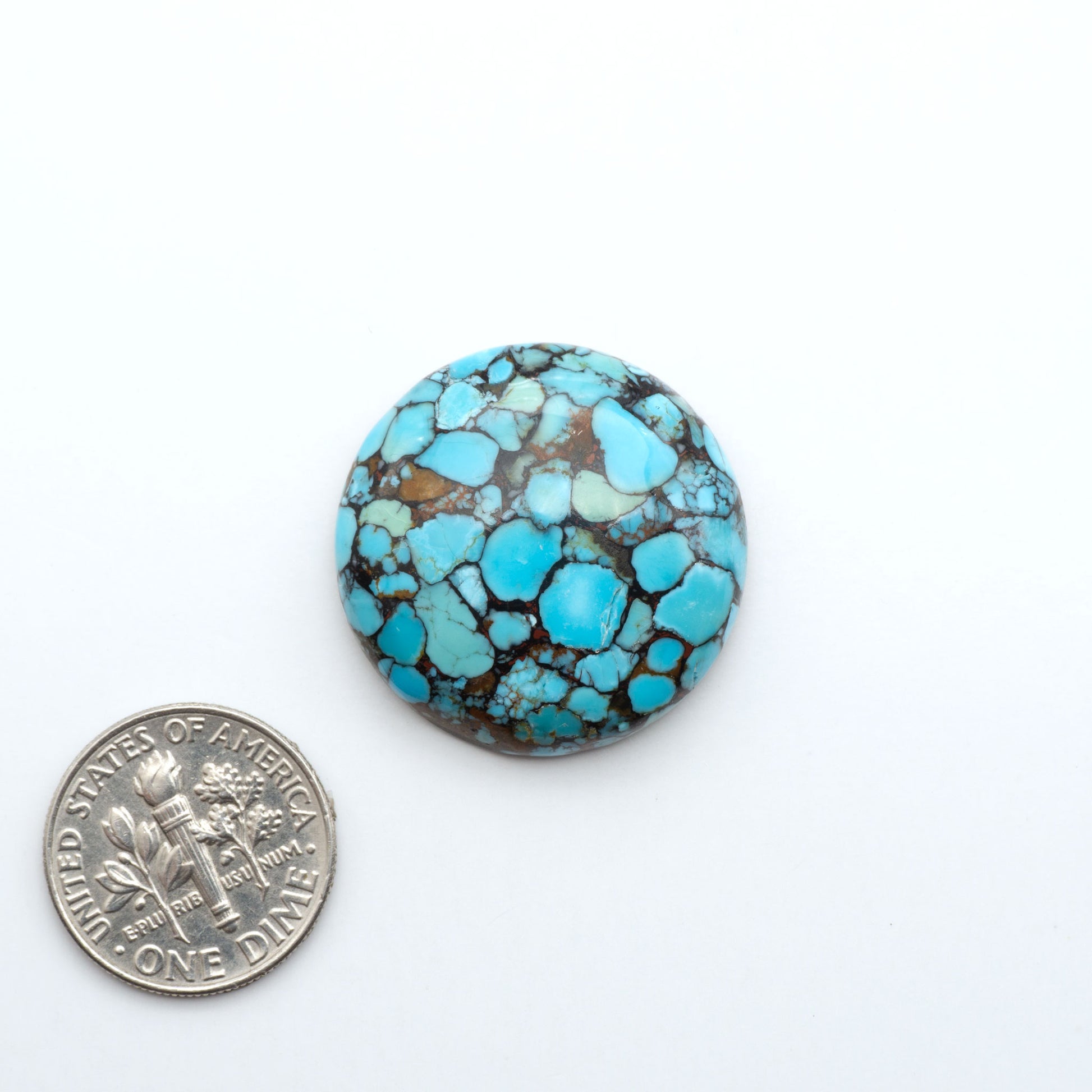 Pressed Turquoise nugget cabochons, composite material with a blue color and dark matrix on a white background, with a US dime for scale.