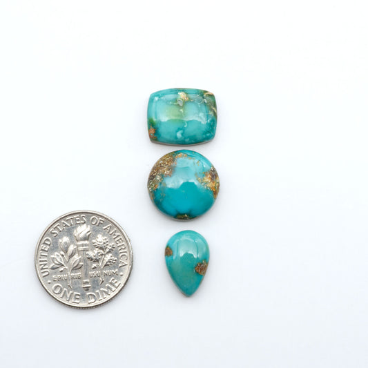Sonoran Mountain Turquoise cabochons, blue-green color with natural matrix, polished stones on a white background, with a US dime for scale