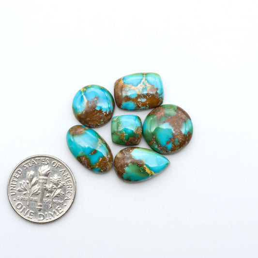 Sonoran Mountain Turquoise cabochons, blue-green color with natural matrix, polished stones on a white background, with a US dime for scale
