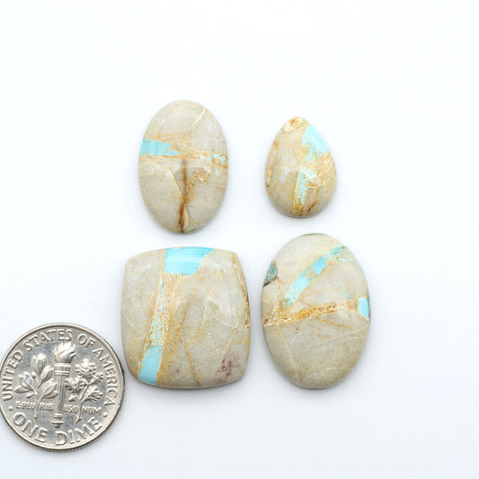 Royston Turquoise cabochons, blue-green color with natural matrix, polished stones on a white background, with a US dime for scale