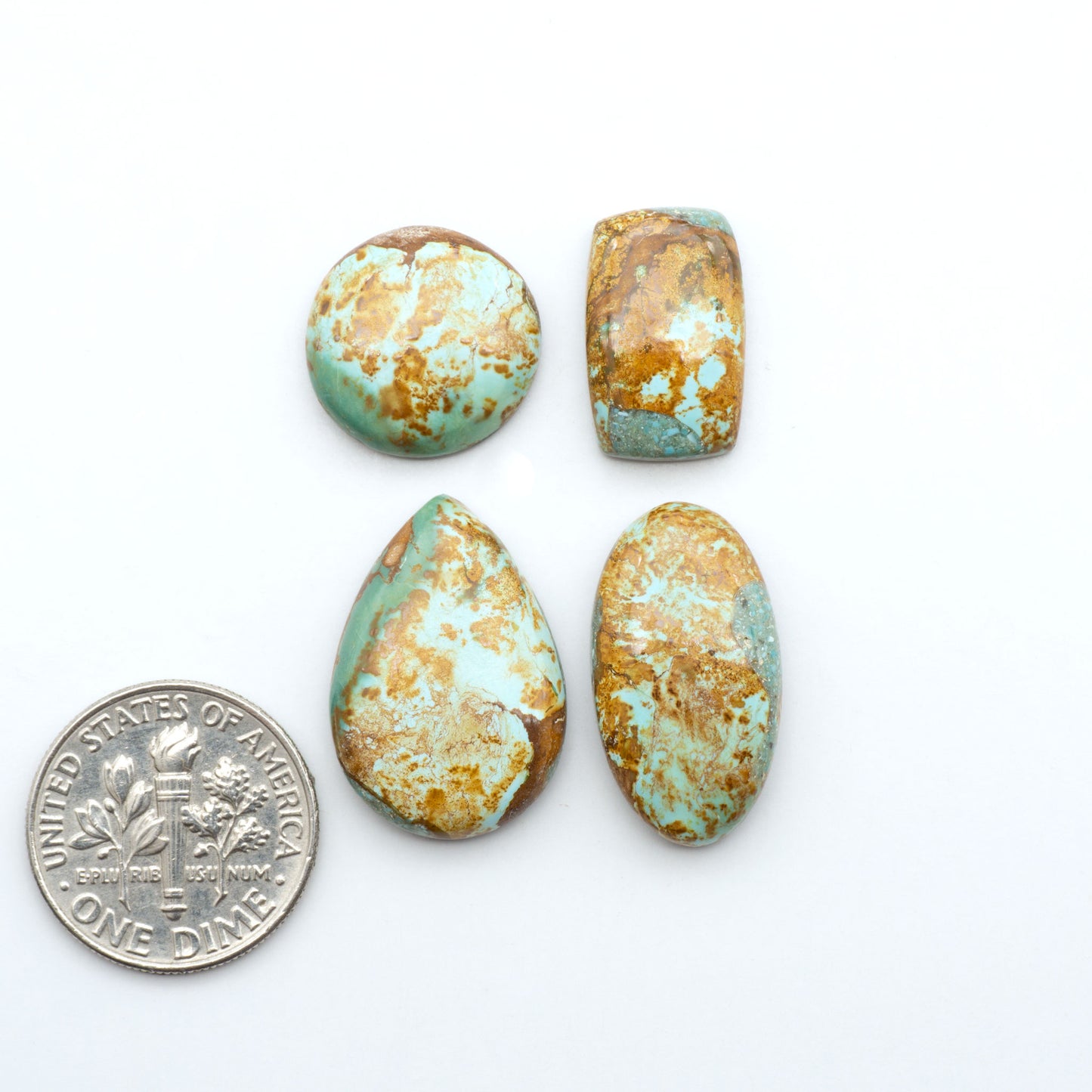 Royston Turquoise cabochons, blue-green color with natural matrix, polished stones on a white background, with a US dime for scale