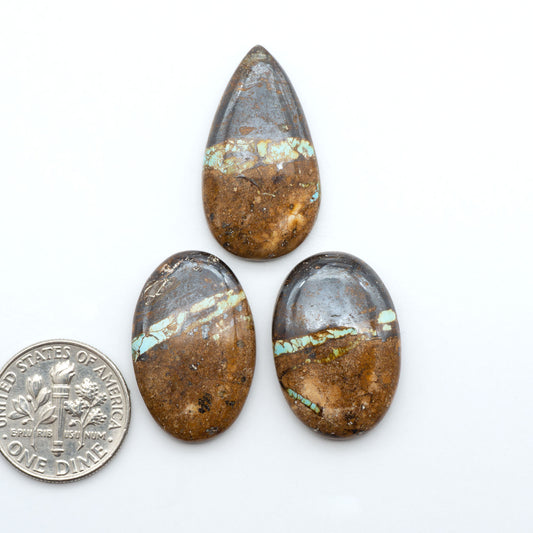 Royston Turquoise cabochons, blue-green color with natural matrix, polished stones on a white background, with a US dime for scale