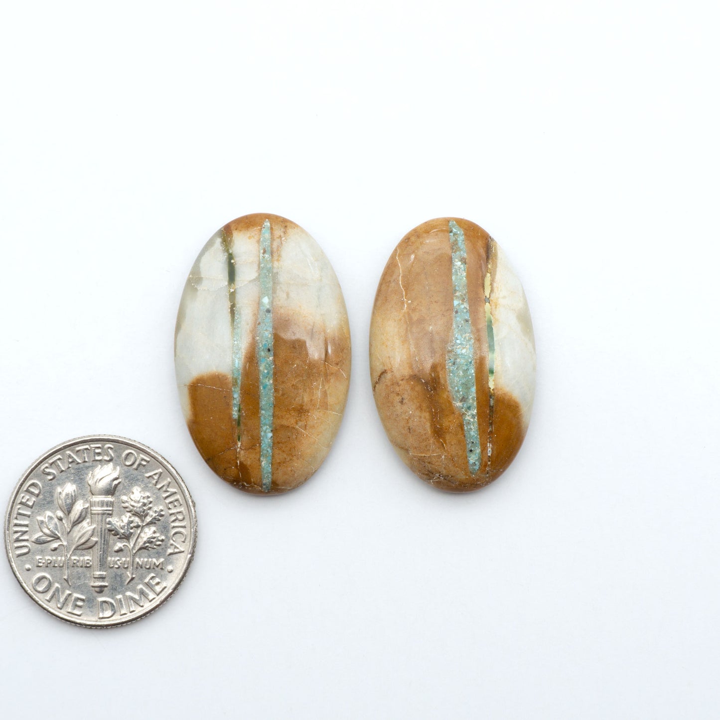 Royston Turquoise cabochons, blue-green color with natural matrix, polished stones on a white background, with a US dime for scale