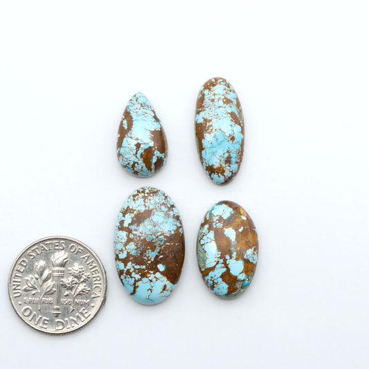 Royston Turquoise cabochons, blue-green color with natural matrix, polished stones on a white background, with a US dime for scale