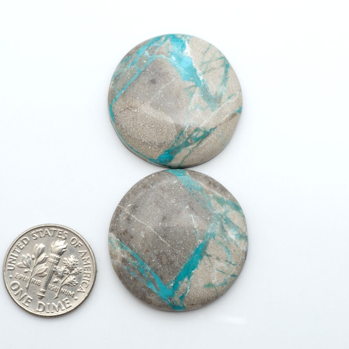 Carico Lake Turquoise cabochons, aqua-blue to turquoise gemstones with natural matrix on a white background with a US dime for scale