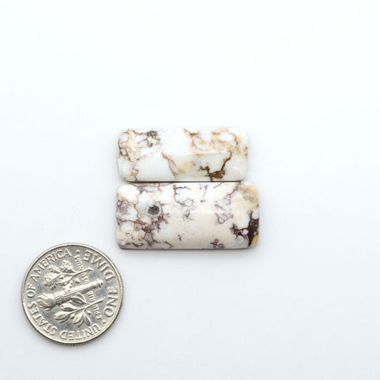 Wild Horse Magnesite cabochons, white gemstones with brown matrix on a white background, with a US dime for scale
