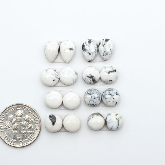 White Buffalo stone cabochons, white stone with black matrix, polished stones on a white background, with a US dime for scale