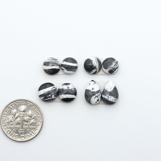 White Buffalo stone cabochons, white stone with black matrix, polished stones on a white background, with a US dime for scale