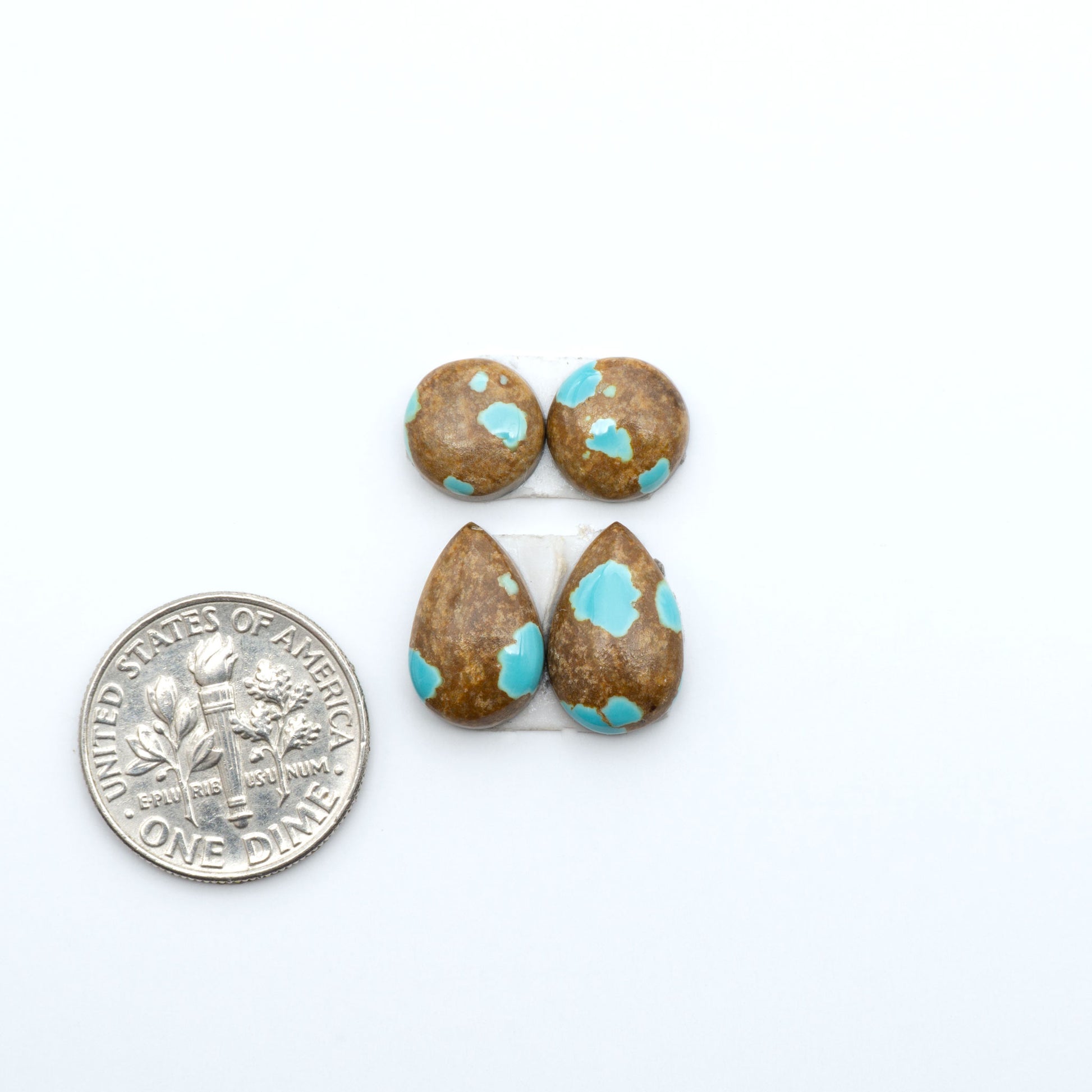 Number 8 Turquoise cabochons, blue and green color with brown matrix, polished stones on a white background, with a US dime for scale