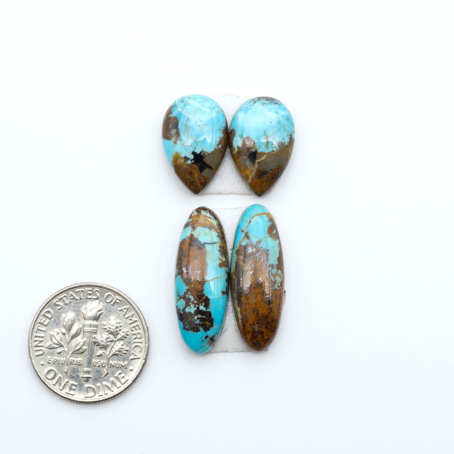 Number 8 Turquoise cabochons, blue and green color with brown matrix, polished stones on a white background, with a US dime for scale
