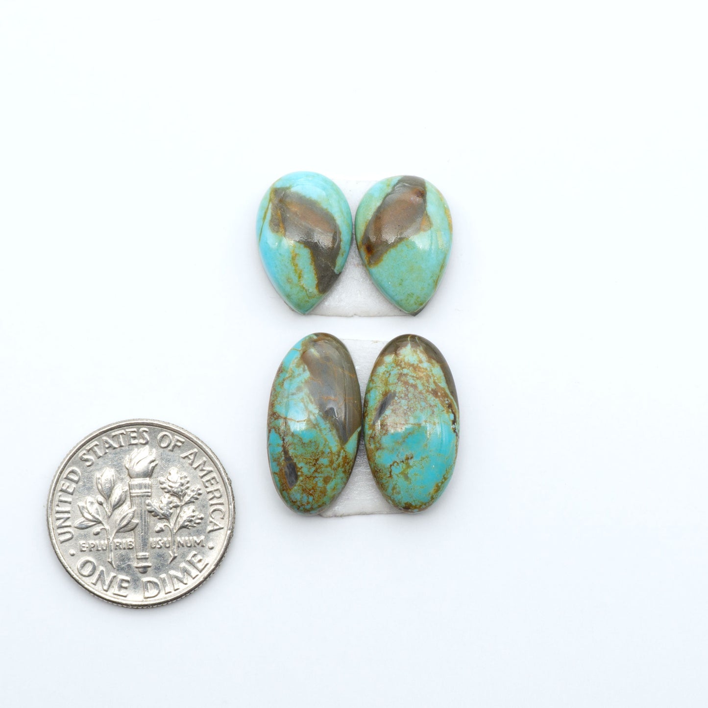 Number 8 Turquoise cabochons, blue and green color with brown matrix, polished stones on a white background, with a US dime for scale