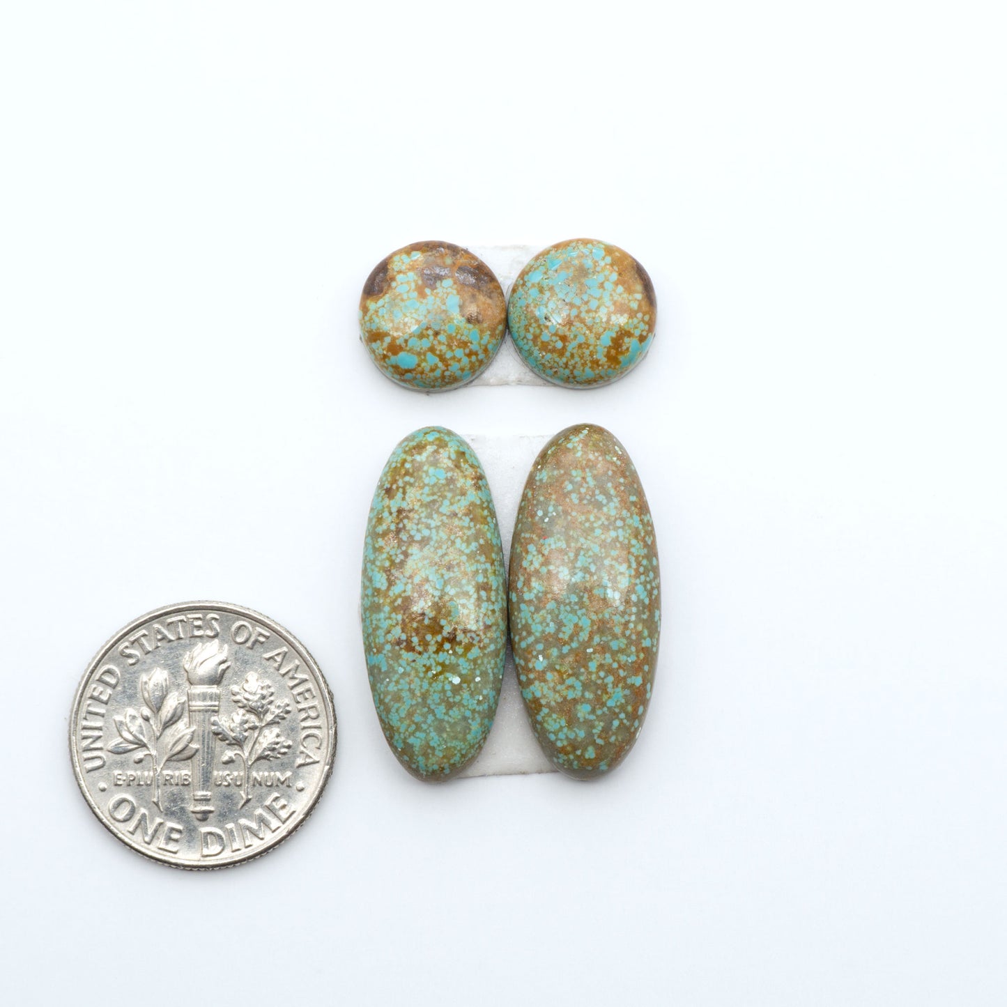 Number 8 Turquoise cabochons, blue and green color with brown matrix, polished stones on a white background, with a US dime for scale
