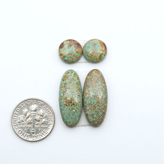 Number 8 Turquoise cabochons, blue and green color with brown matrix, polished stones on a white background, with a US dime for scale