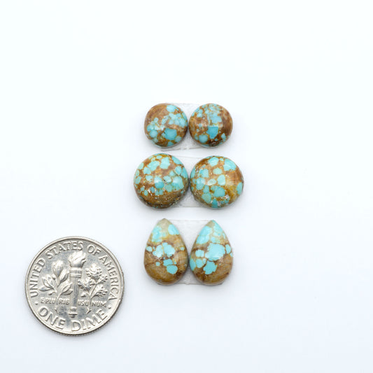 Number 8 Turquoise cabochons, blue and green color with brown matrix, polished stones on a white background, with a US dime for scale