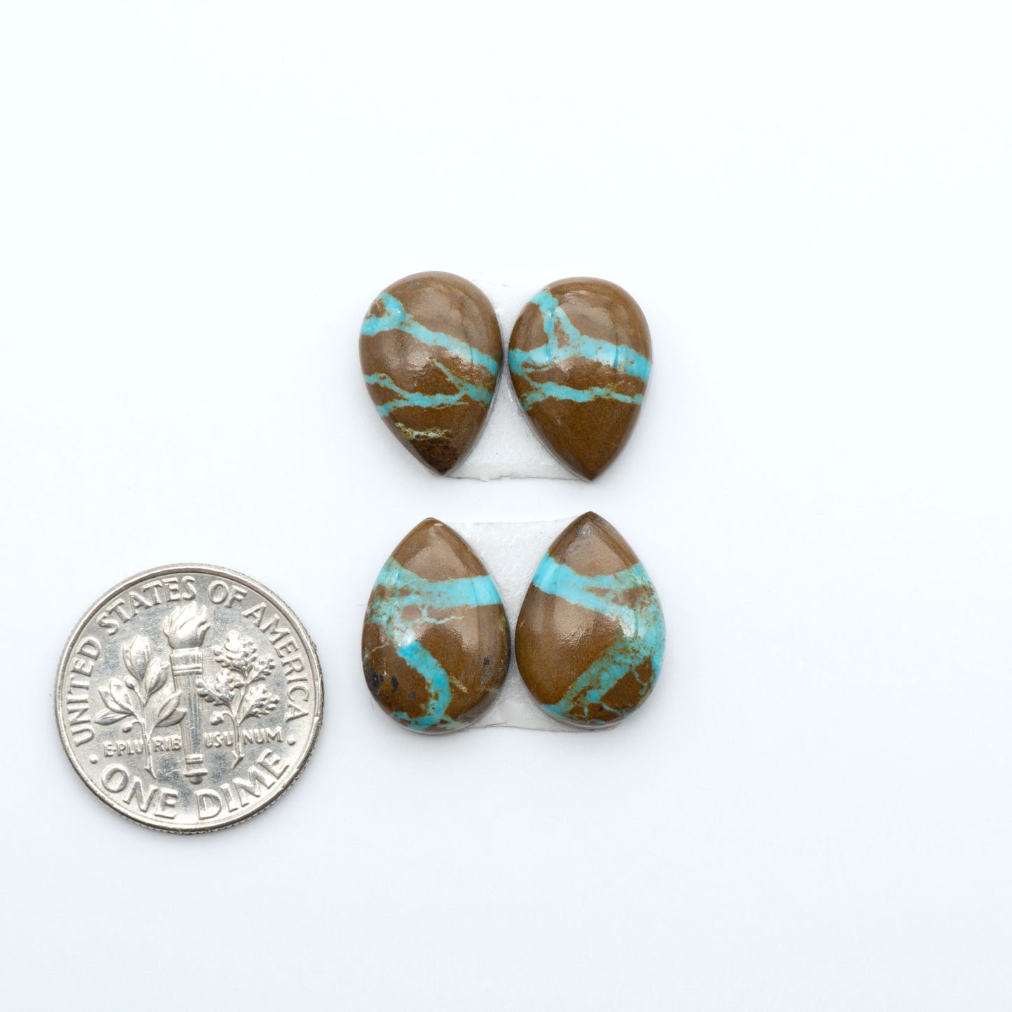 Number 8 Turquoise cabochons, blue and green color with brown matrix, polished stones on a white background, with a US dime for scale