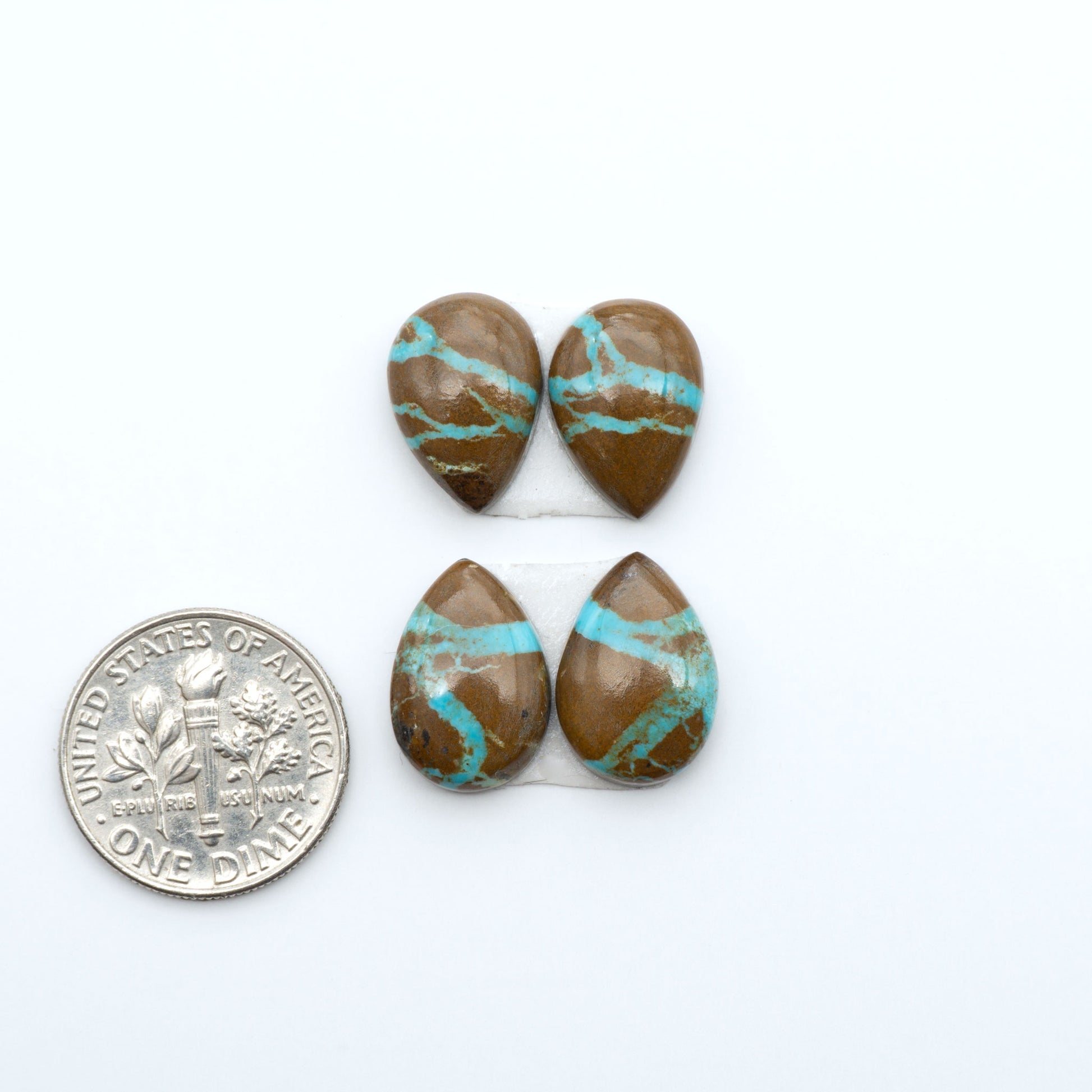 Number 8 Turquoise cabochons, blue and green color with brown matrix, polished stones on a white background, with a US dime for scale