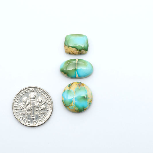Sonoran Mountain Turquoise cabochons, blue-green color with natural matrix, polished stones on a white background, with a US dime for scale