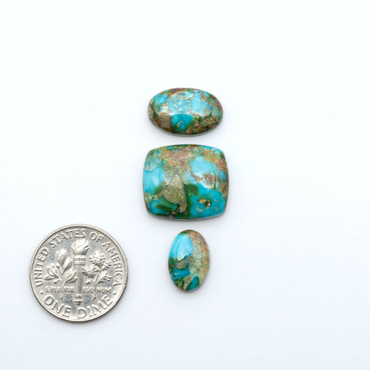 Sonoran Mountain Turquoise cabochons, blue-green color with natural matrix, polished stones on a white background, with a US dime for scale