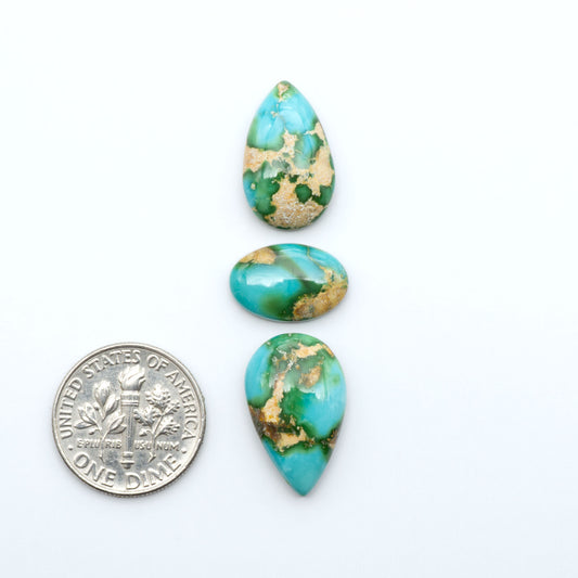 Sonoran Mountain Turquoise cabochons, blue-green color with natural matrix, polished stones on a white background, with a US dime for scale