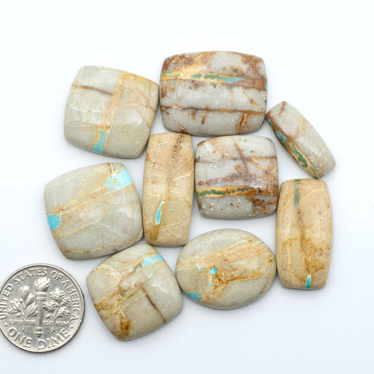 Royston Turquoise cabochons, blue-green color with natural matrix, polished stones on a white background, with a US dime for scale