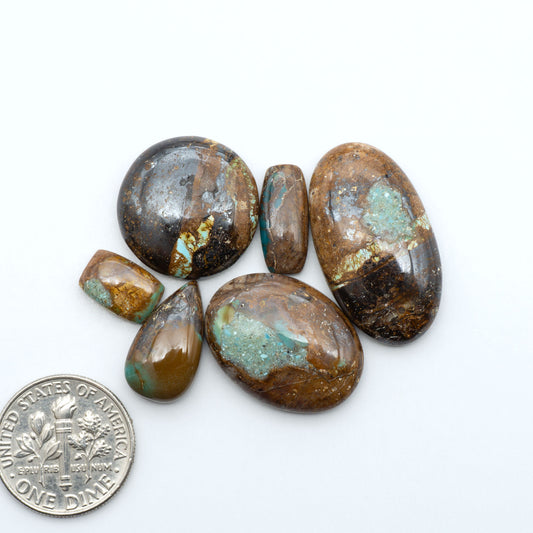 Royston Turquoise cabochons, blue-green color with natural matrix, polished stones on a white background, with a US dime for scale