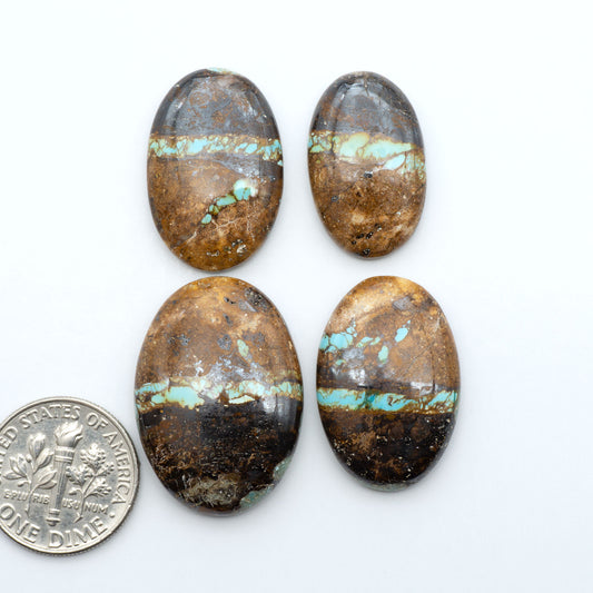 Royston Turquoise cabochons, blue-green color with natural matrix, polished stones on a white background, with a US dime for scale