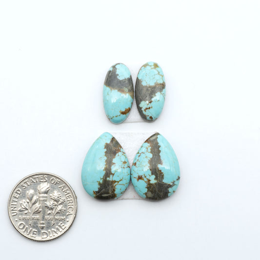 Number 8 Turquoise cabochons, blue and green color with brown matrix, polished stones on a white background, with a US dime for scale