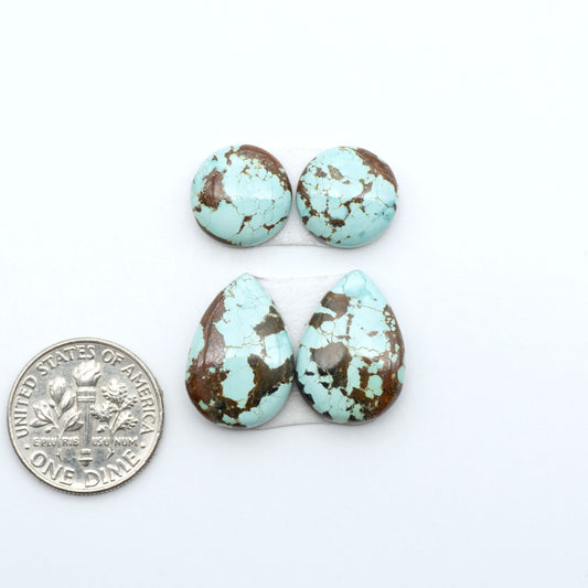 Number 8 Turquoise cabochons, blue and green color with brown matrix, polished stones on a white background, with a US dime for scale