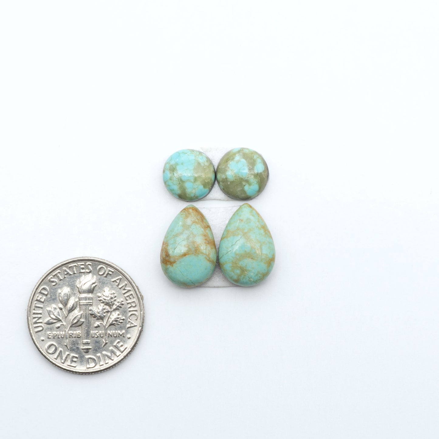 Number 8 Turquoise cabochons, blue and green color with brown matrix, polished stones on a white background, with a US dime for scale
