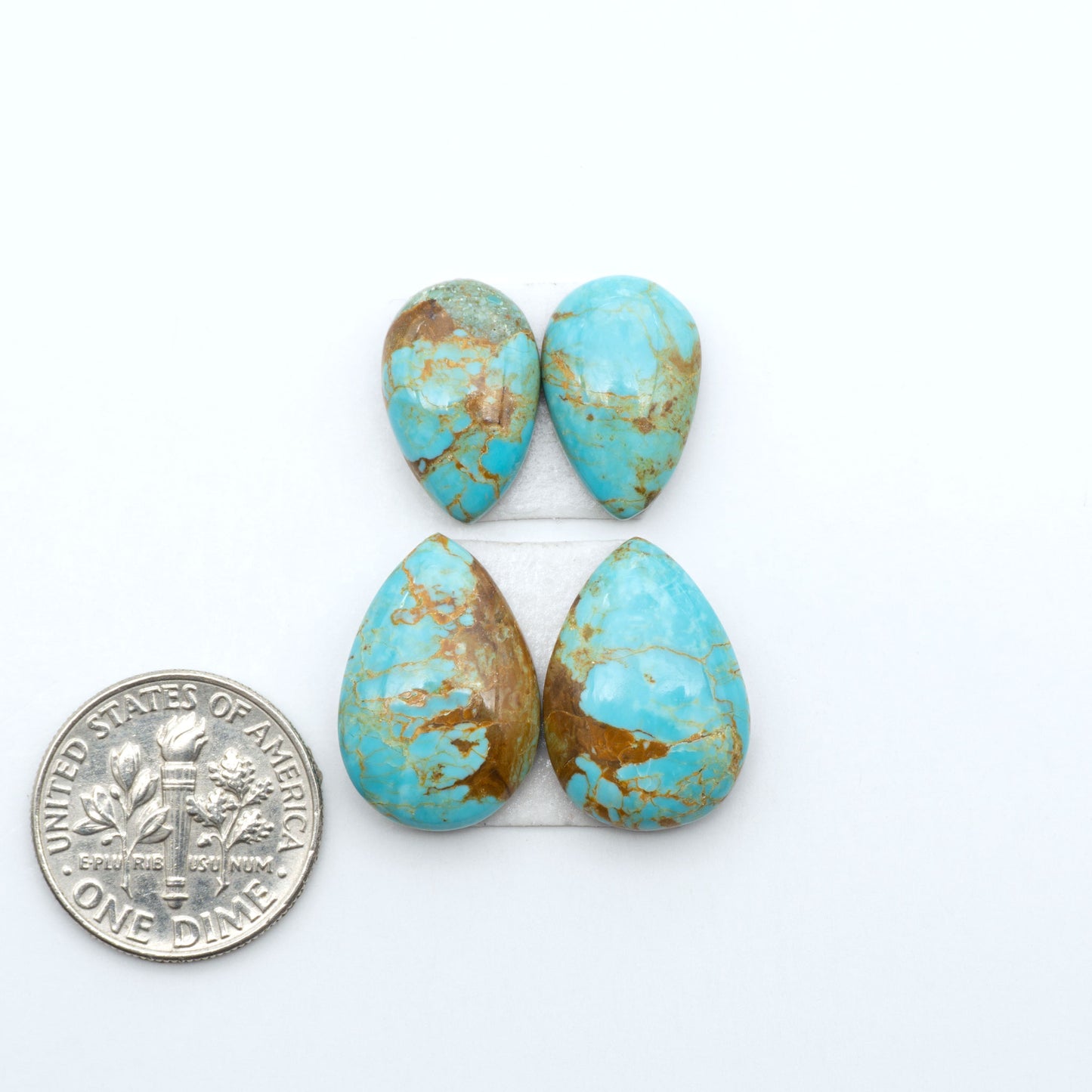 Number 8 Turquoise cabochons, blue and green color with brown matrix, polished stones on a white background, with a US dime for scale
