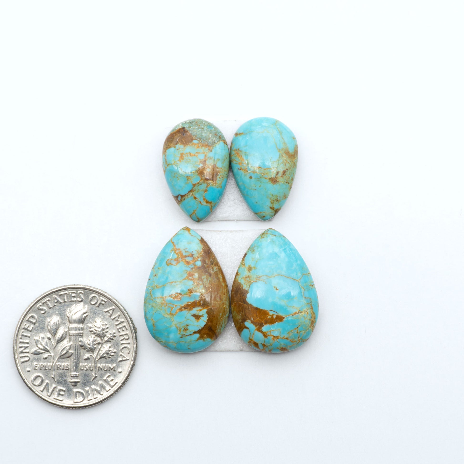 Number 8 Turquoise cabochons, blue and green color with brown matrix, polished stones on a white background, with a US dime for scale