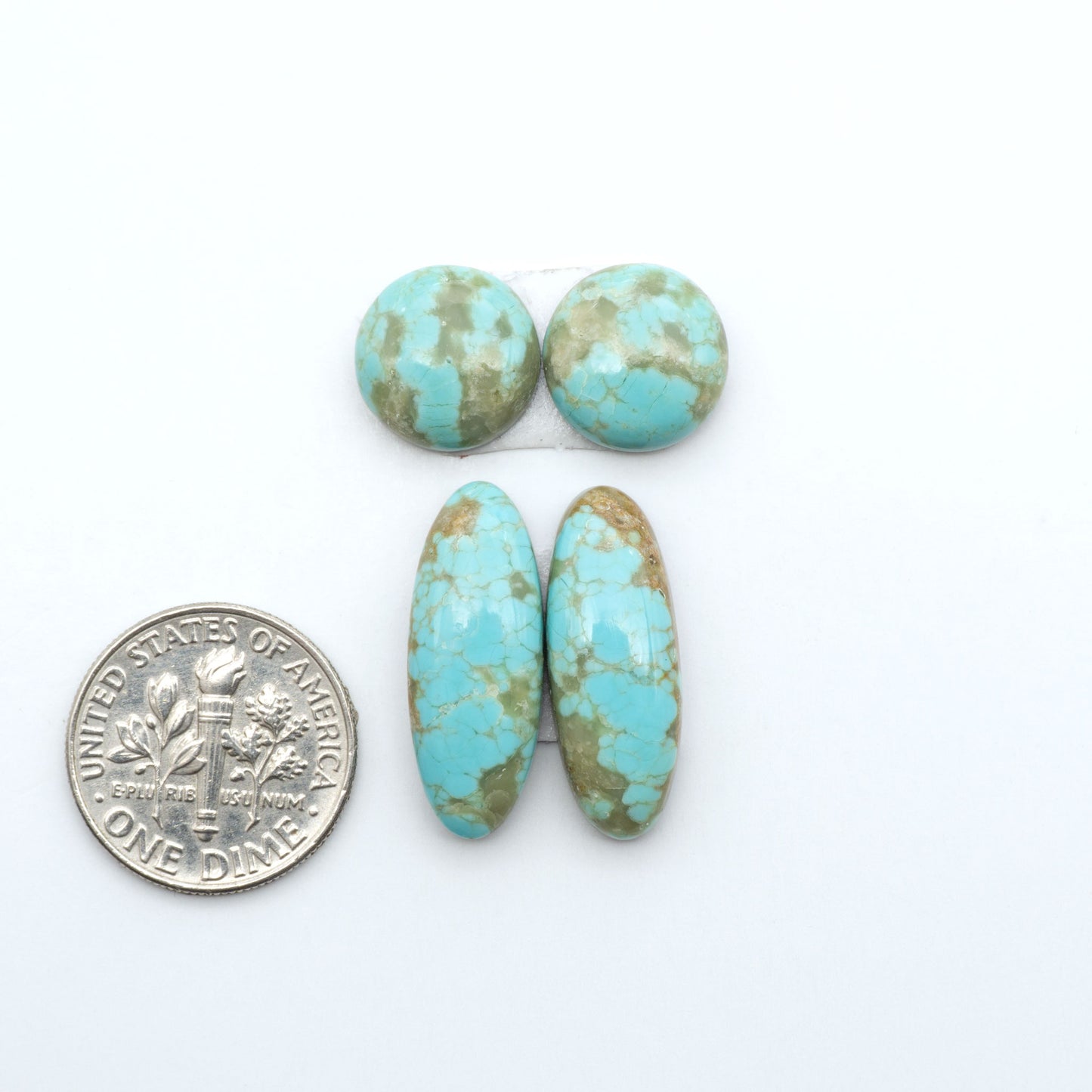 Number 8 Turquoise cabochons, blue and green color with brown matrix, polished stones on a white background, with a US dime for scale