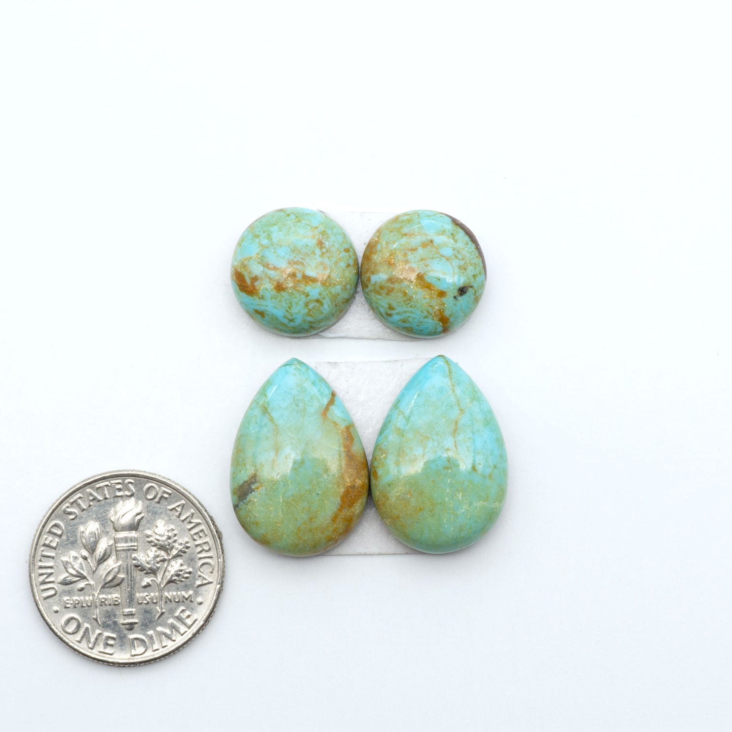 Number 8 Turquoise cabochons, blue and green color with brown matrix, polished stones on a white background, with a US dime for scale