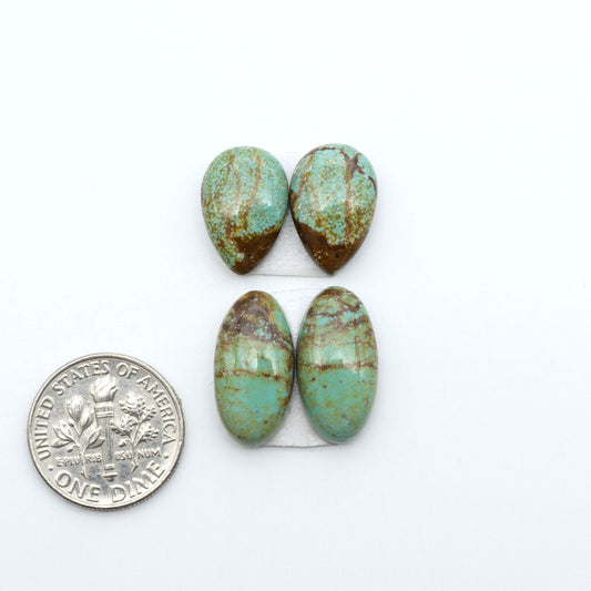 Number 8 Turquoise cabochons, blue and green color with brown matrix, polished stones on a white background, with a US dime for scale