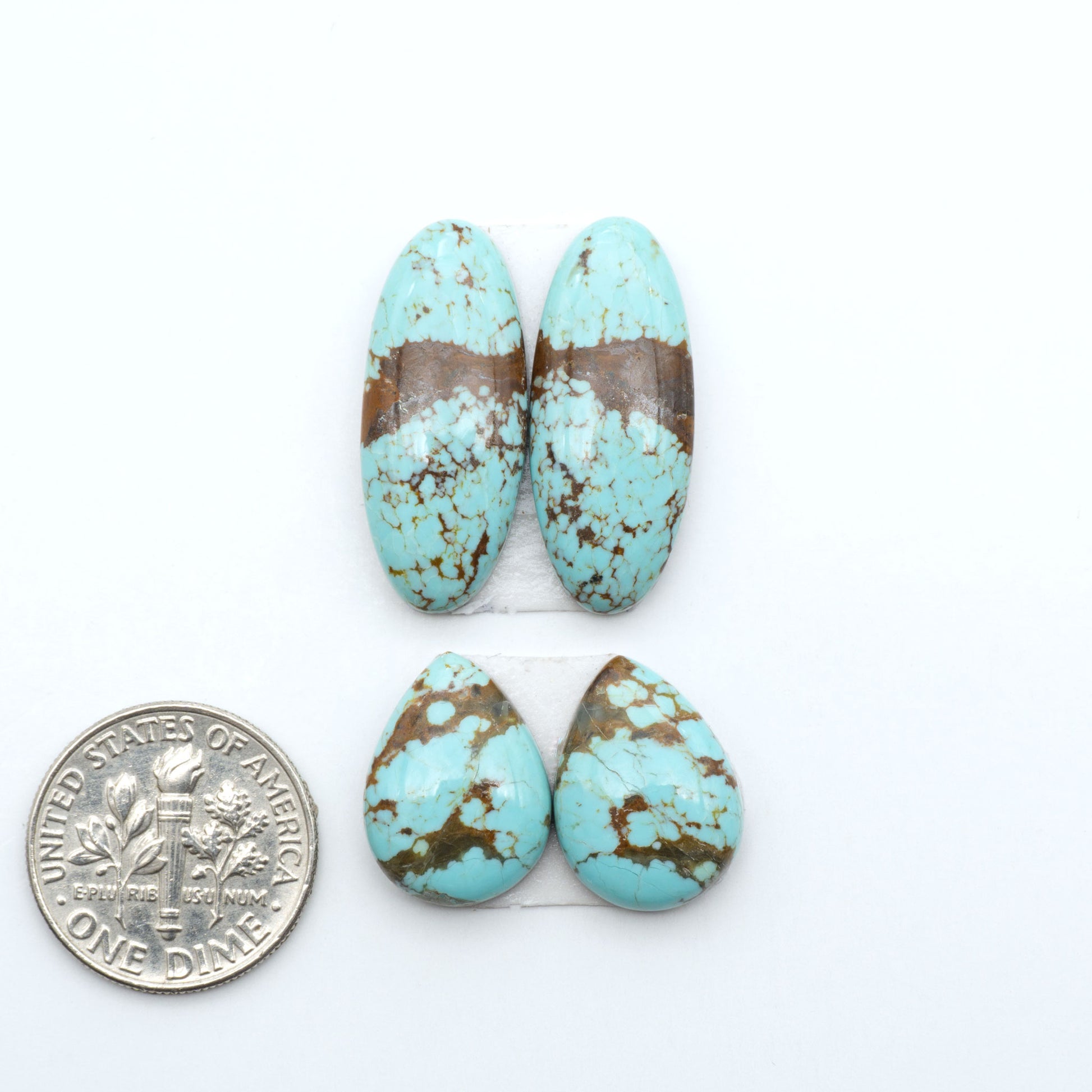 Number 8 Turquoise cabochons, blue and green color with brown matrix, polished stones on a white background, with a US dime for scale