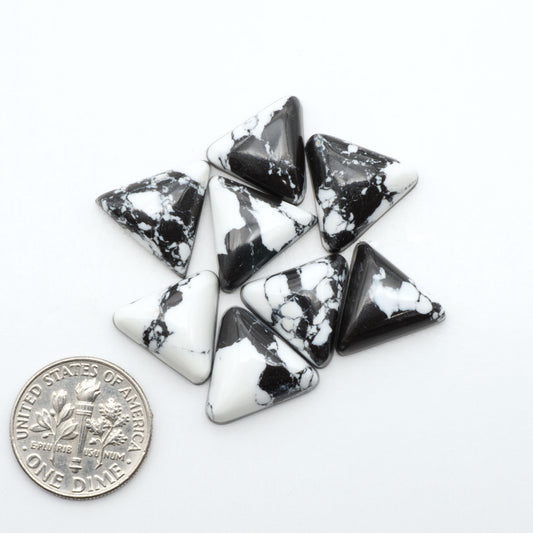 White Buffalo composite cabochons, black and white gemstones on a white background with a US dime for scale