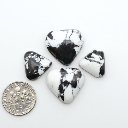 White Buffalo composite cabochons, black and white gemstones on a white background with a US dime for scale