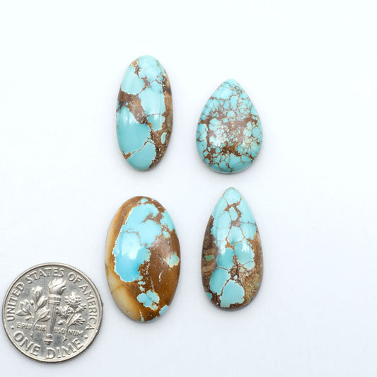Royston Turquoise cabochons, blue-green color with natural matrix, polished stones on a white background, with a US dime for scale