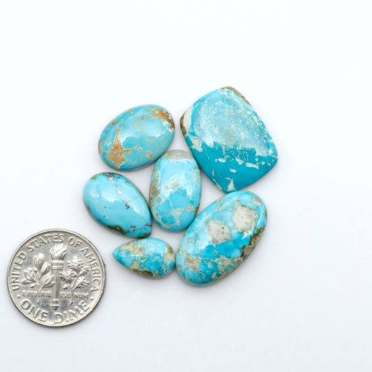 Royston Turquoise cabochons, blue-green color with natural matrix, polished stones on a white background, with a US dime for scale