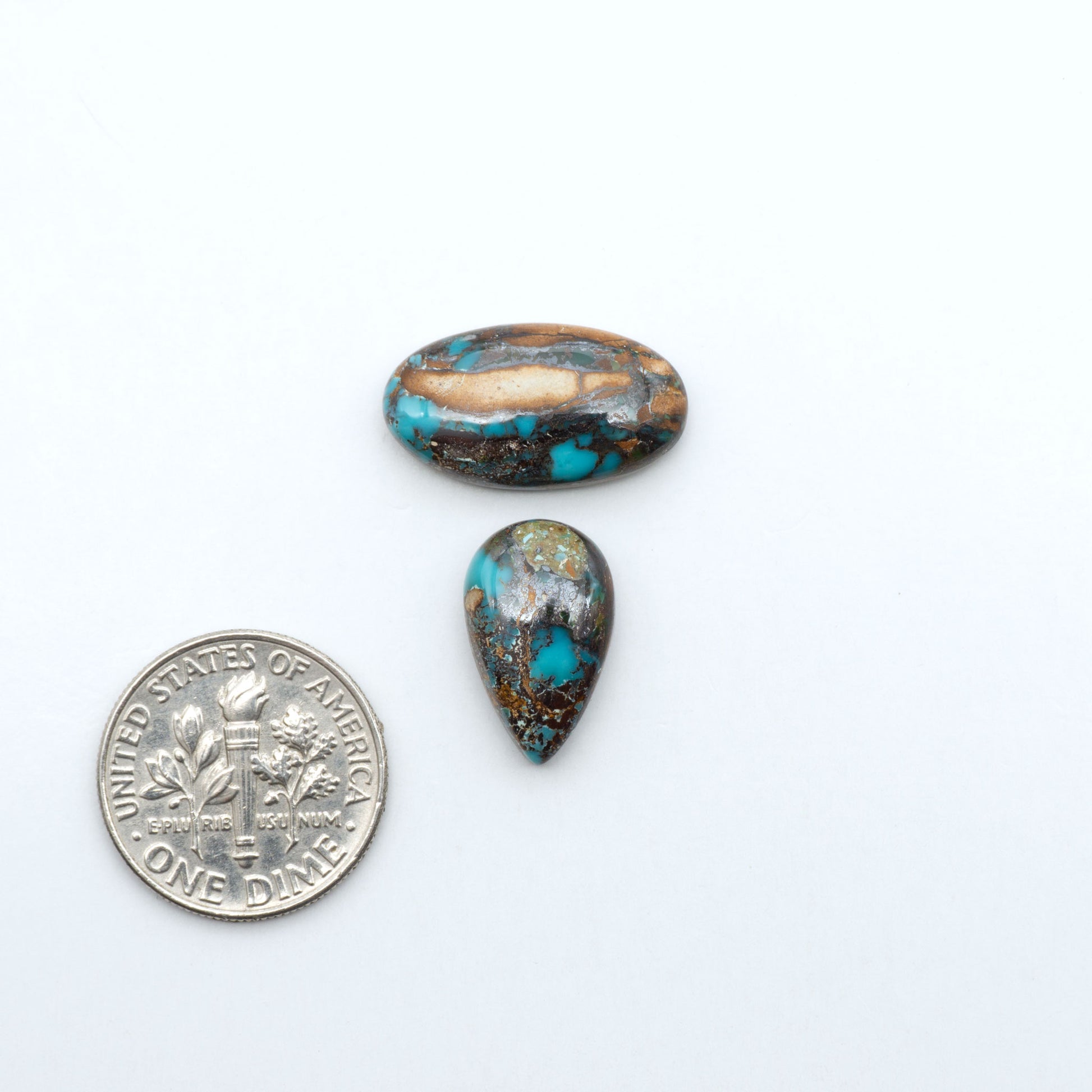 Royston Turquoise cabochons, blue-green color with natural matrix, polished stones on a white background, with a US dime for scale