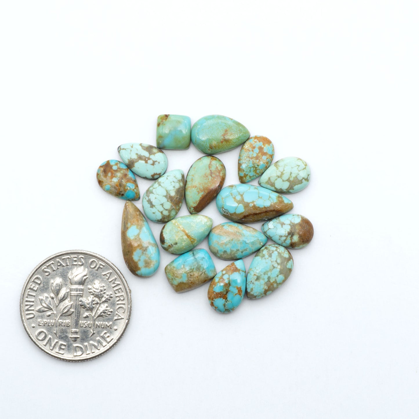 Number 8 Turquoise cabochons, blue and green color with brown matrix, polished stones on a white background, with a US dime for scale