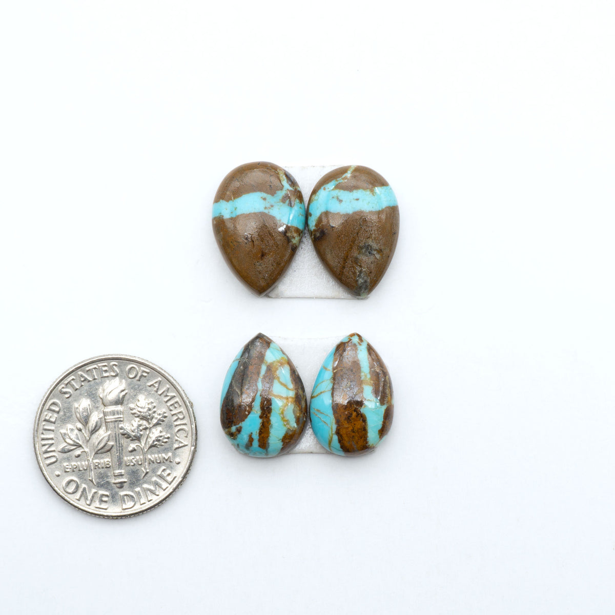 Number 8 Turquoise cabochons, blue and green color with brown matrix, polished stones on a white background, with a US dime for scale