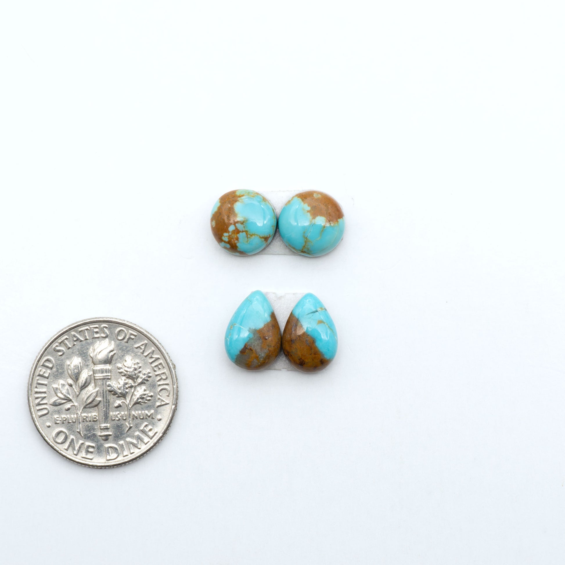 Number 8 Turquoise cabochons, blue and green color with brown matrix, polished stones on a white background, with a US dime for scale