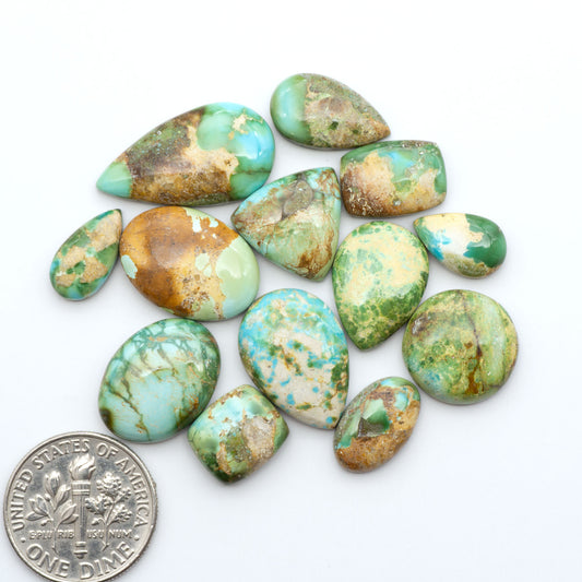 Sonoran Mountain Turquoise cabochons, blue-green color with natural matrix, polished stones on a white background, with a US dime for scale