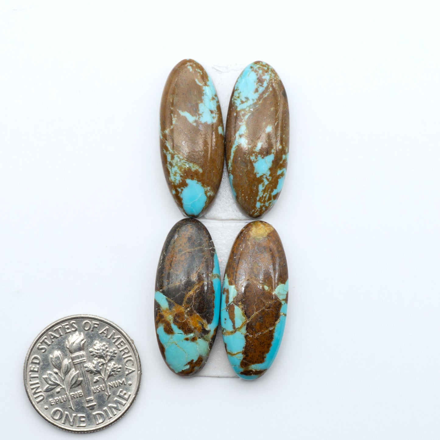 Number 8 Turquoise cabochons, blue and green color with brown matrix, polished stones on a white background, with a US dime for scale