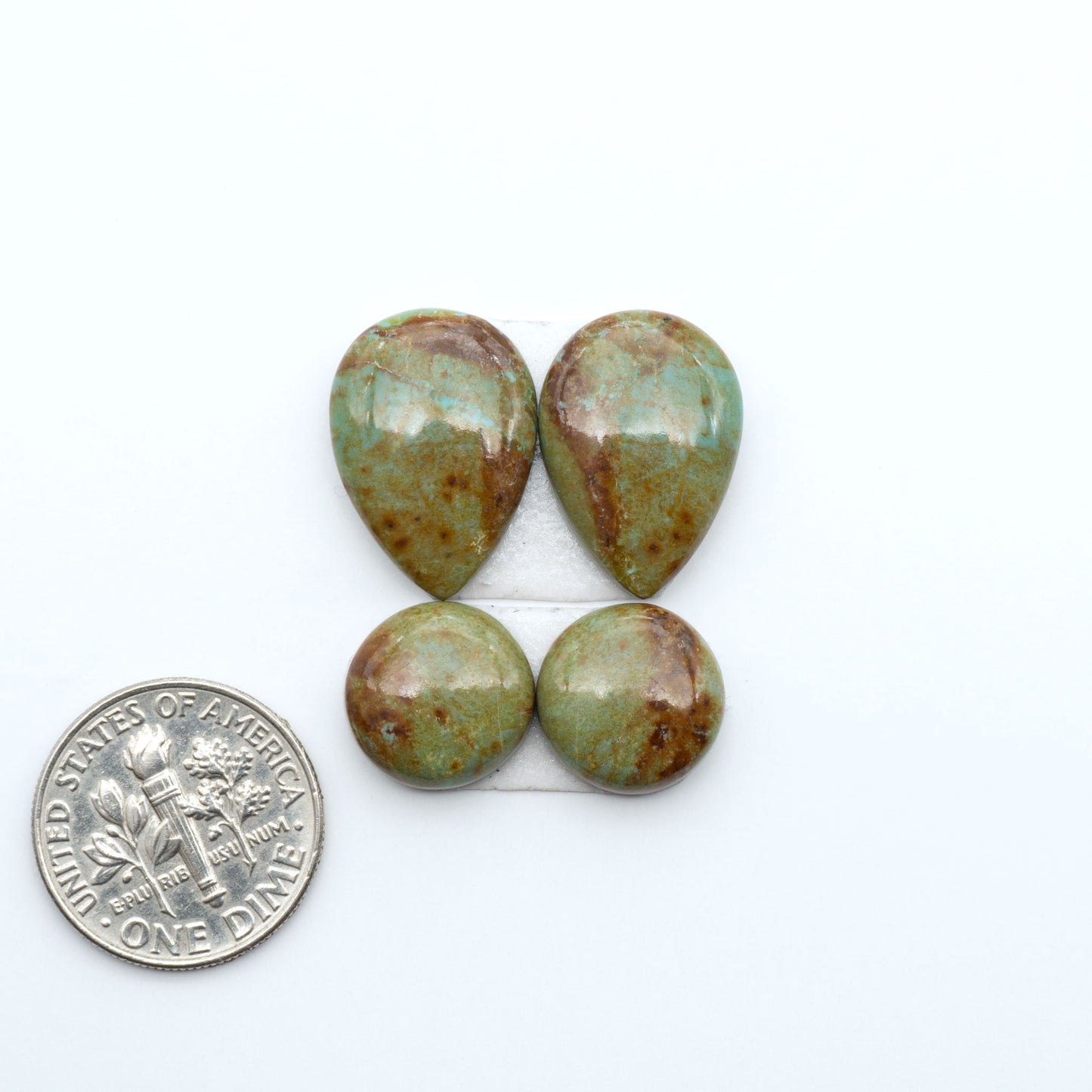 Number 8 Turquoise cabochons, blue and green color with brown matrix, polished stones on a white background, with a US dime for scale