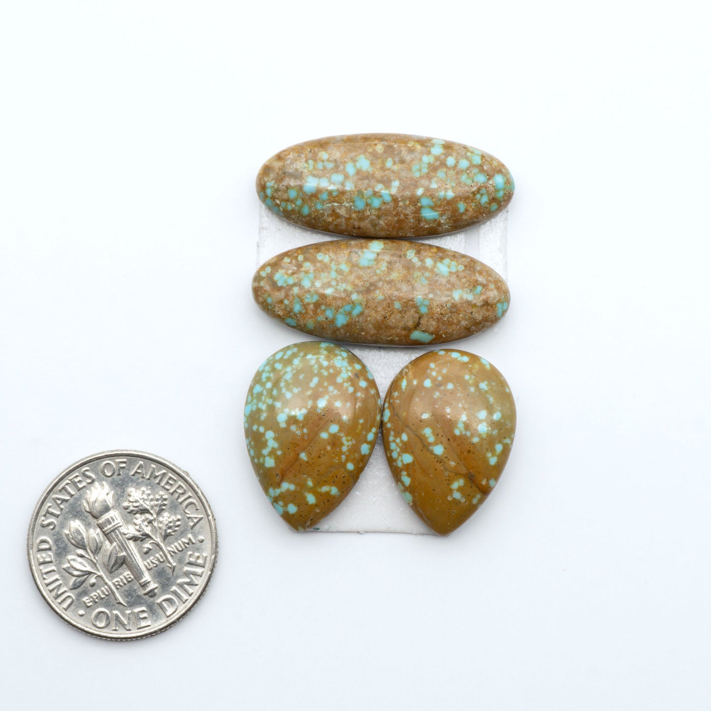 Number 8 Turquoise cabochons, blue and green color with brown matrix, polished stones on a white background, with a US dime for scale